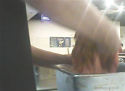 在开餐前，烤肉店一名员工正徒手搅拌肉片。

